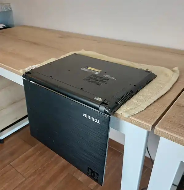 Laptop en L invertida en la orilla de la mesa